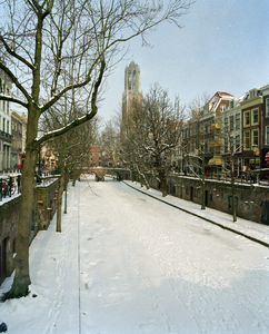 805682 Gezicht op een bevroren en met sneeuw bedekte Oudegracht te Utrecht, vanaf de Hamburgerbrug, uit het zuiden; op ...